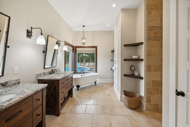 bathroom featuring a notable chandelier, vanity, and a tub