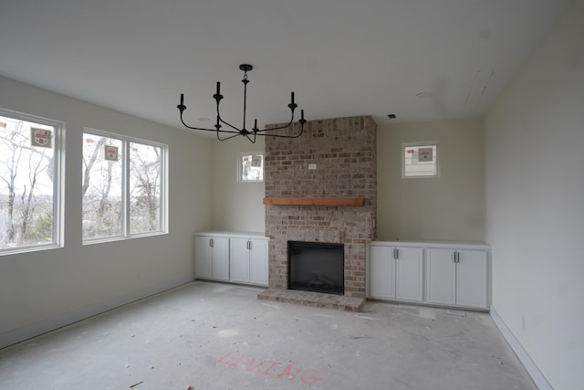 unfurnished living room with a notable chandelier and a fireplace