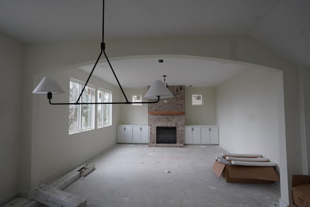 unfurnished living room featuring a fireplace and vaulted ceiling