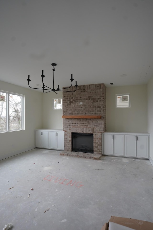 unfurnished living room with a notable chandelier and a fireplace