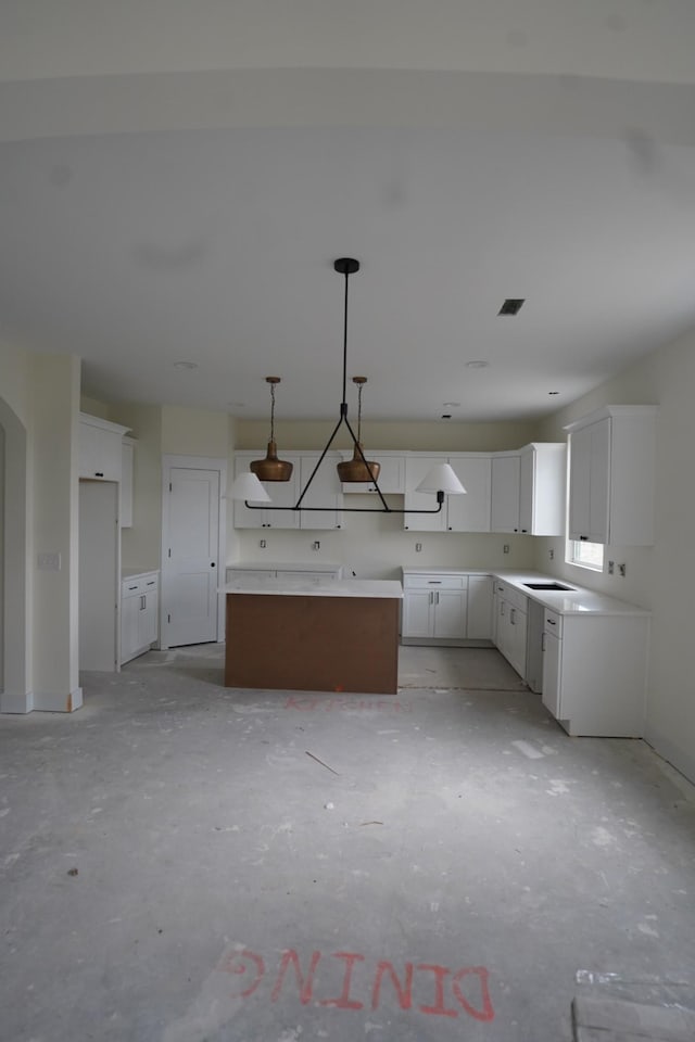 kitchen with decorative light fixtures, a center island, and white cabinets