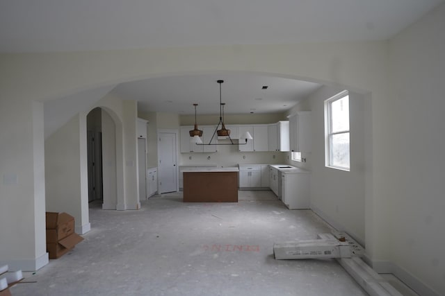 kitchen featuring a center island, white cabinets, and decorative light fixtures