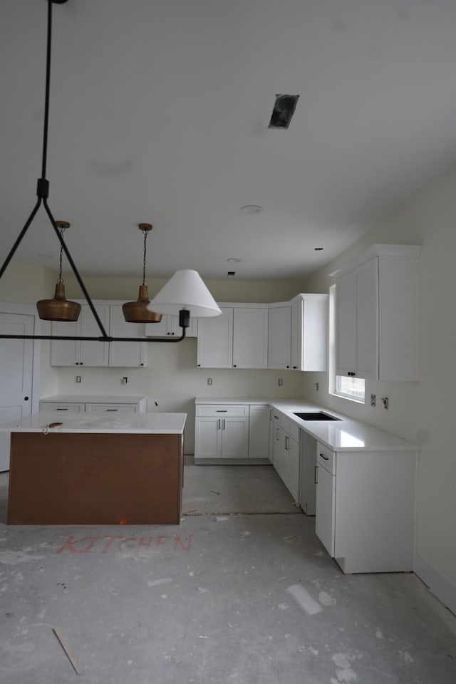 kitchen featuring sink, decorative light fixtures, and white cabinets