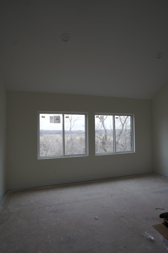 empty room with plenty of natural light and vaulted ceiling