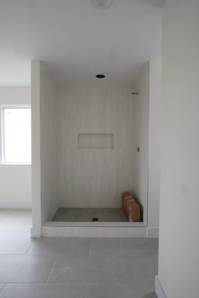 bathroom featuring tile patterned flooring and a tile shower