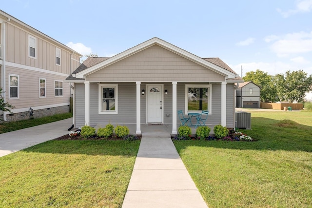 view of front of home with covered porch, central air condition unit, and a front yard