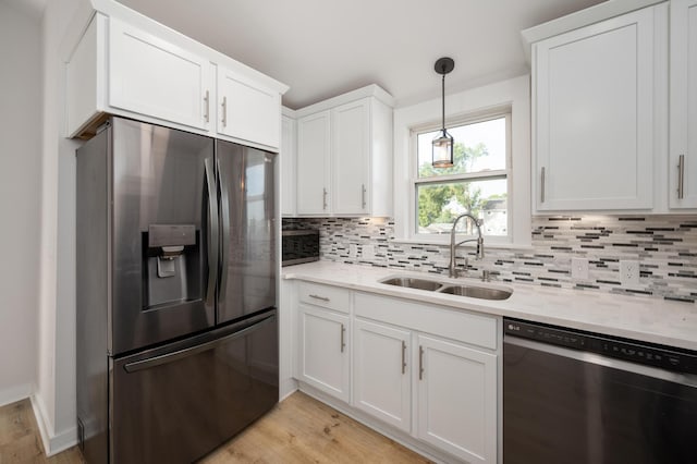 kitchen with white cabinetry, sink, light hardwood / wood-style floors, and appliances with stainless steel finishes