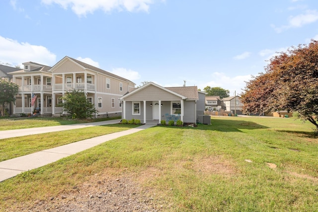 view of front of home featuring covered porch, central AC, and a front lawn