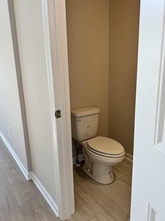 bathroom with hardwood / wood-style flooring and toilet