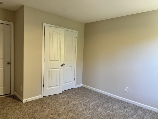 unfurnished bedroom featuring carpet and a closet