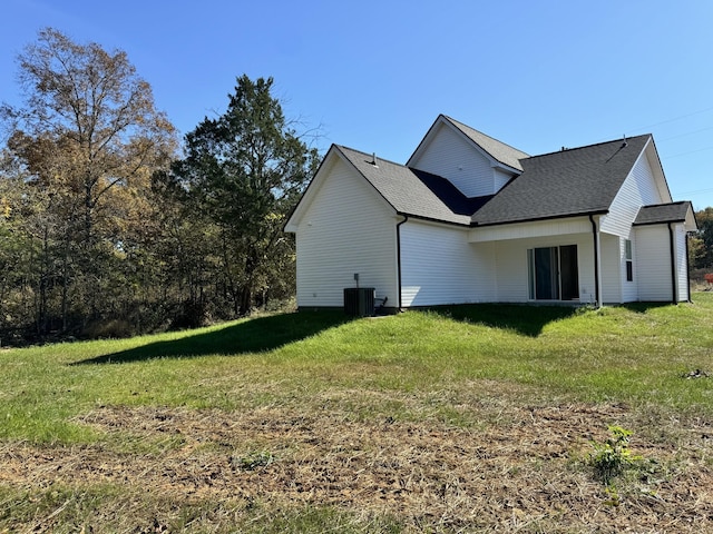 view of side of home featuring a yard and central AC unit