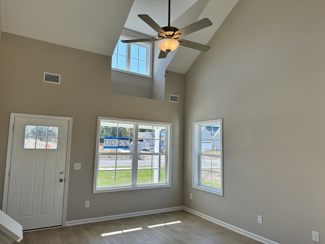 foyer with ceiling fan, light wood-type flooring, plenty of natural light, and high vaulted ceiling