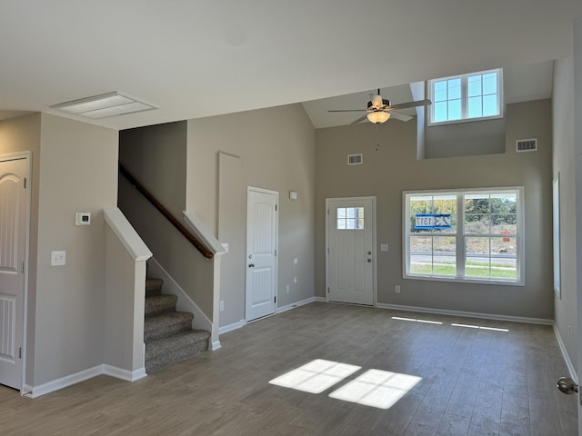 entrance foyer with a towering ceiling, light hardwood / wood-style flooring, and ceiling fan