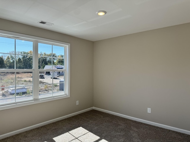 unfurnished room featuring dark colored carpet