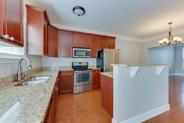 kitchen with appliances with stainless steel finishes, crown molding, sink, pendant lighting, and a notable chandelier