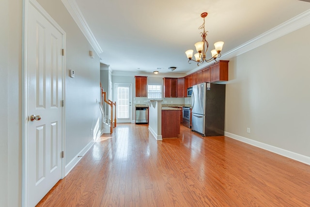 kitchen featuring stainless steel appliances, a chandelier, decorative light fixtures, a kitchen island, and ornamental molding