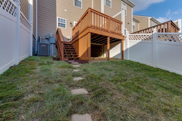 back of property with a lawn, a wooden deck, and central air condition unit