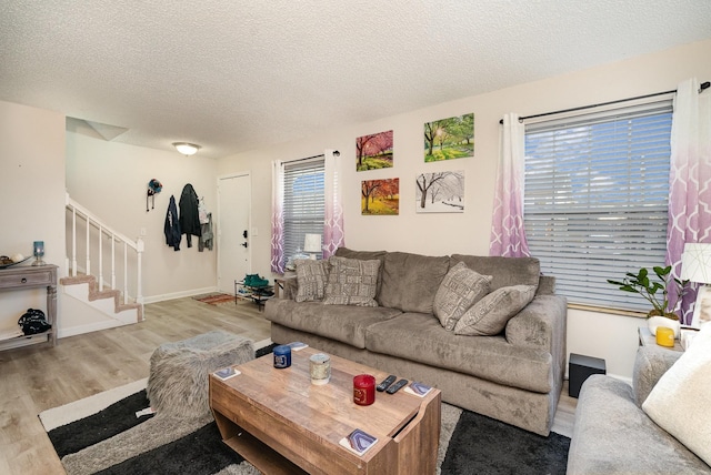 living room featuring light hardwood / wood-style flooring and a textured ceiling