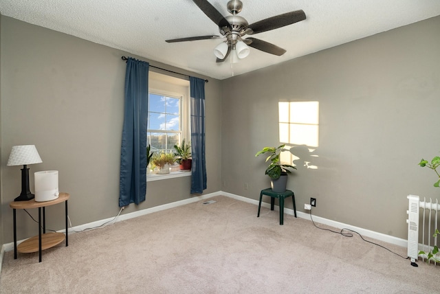 carpeted empty room with radiator heating unit, a textured ceiling, and ceiling fan