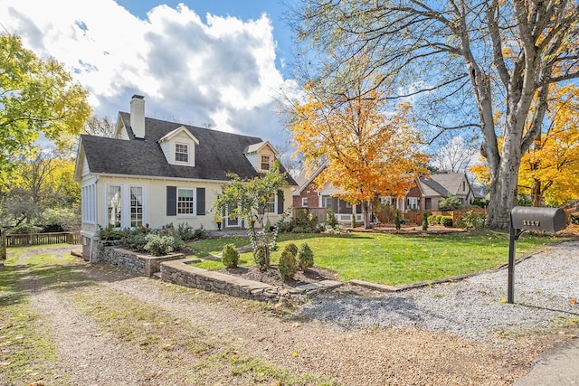 cape cod home with a front yard