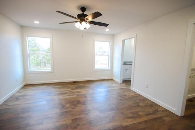 unfurnished room featuring ceiling fan and dark wood-type flooring