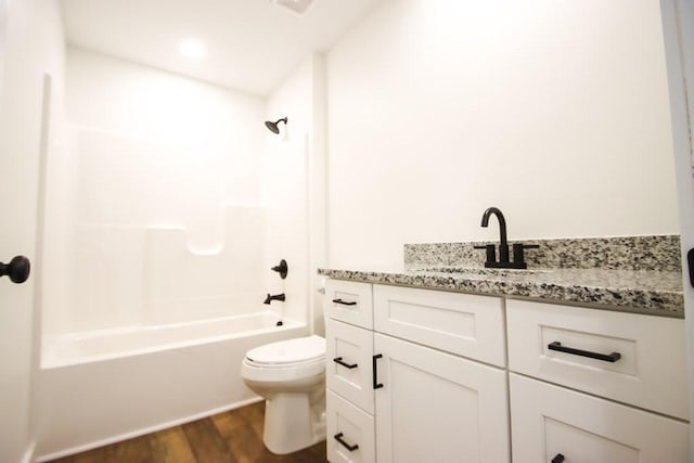 full bathroom with bathtub / shower combination, hardwood / wood-style floors, vanity, and toilet