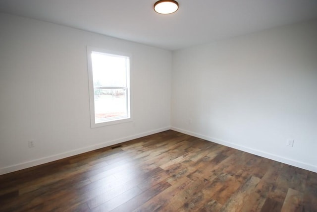 spare room featuring dark wood-type flooring