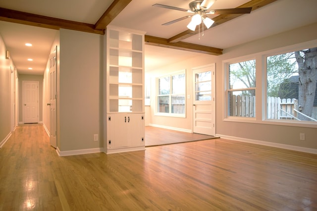 interior space featuring built in shelves, ceiling fan, beamed ceiling, and light hardwood / wood-style floors