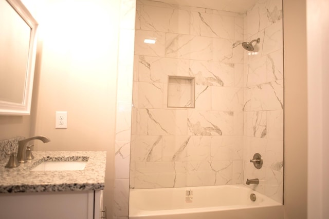 bathroom featuring vanity and tiled shower / bath