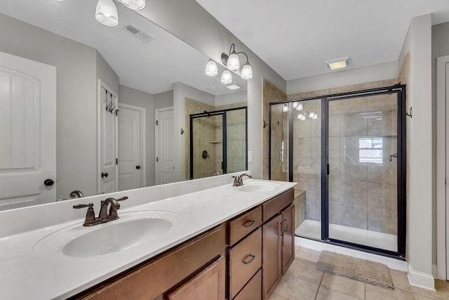 bathroom with tile patterned flooring, vanity, and a shower with shower door