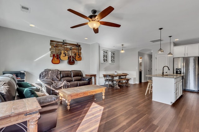 living room with ceiling fan, sink, and dark hardwood / wood-style floors