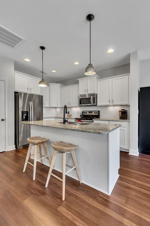 kitchen featuring white cabinetry, an island with sink, and stainless steel appliances