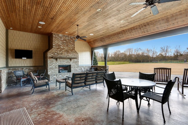 view of patio / terrace with an outdoor living space with a fireplace and ceiling fan