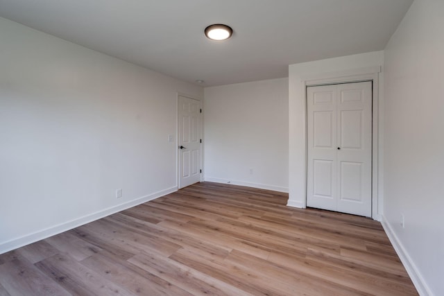 unfurnished bedroom with a closet and light hardwood / wood-style floors