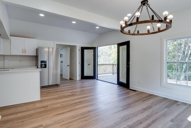 kitchen with pendant lighting, white cabinetry, french doors, an inviting chandelier, and stainless steel fridge