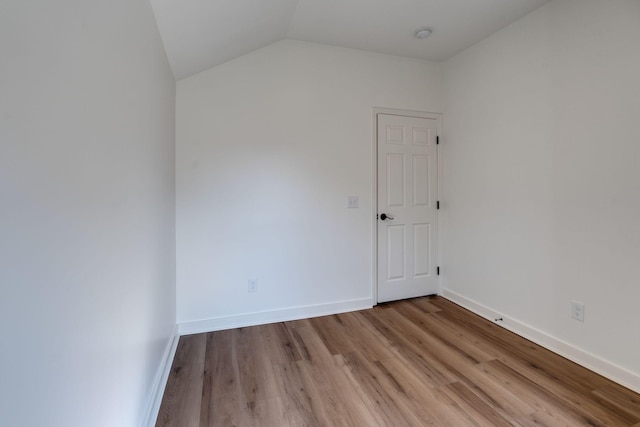 empty room featuring light wood-type flooring and lofted ceiling