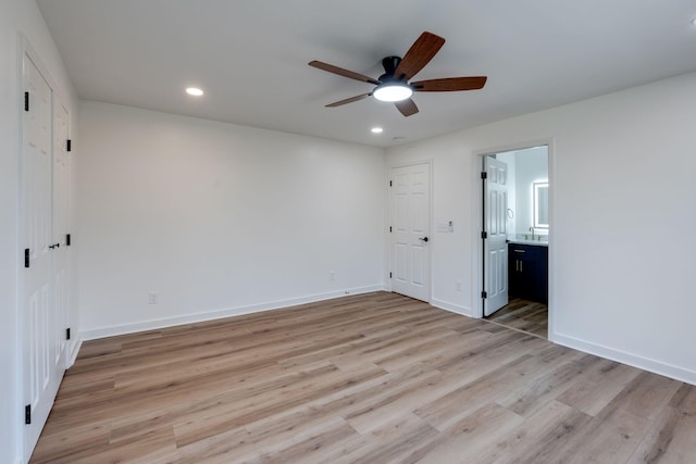 unfurnished bedroom featuring ceiling fan, ensuite bathroom, and light hardwood / wood-style flooring