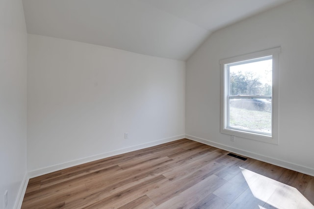 empty room with lofted ceiling and light wood-type flooring