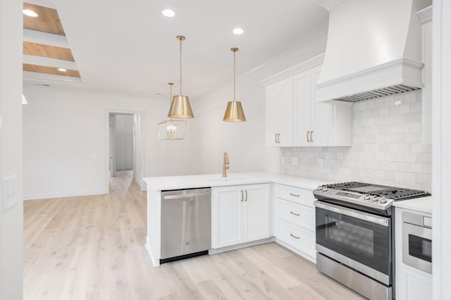 kitchen featuring appliances with stainless steel finishes, sink, white cabinetry, and custom exhaust hood