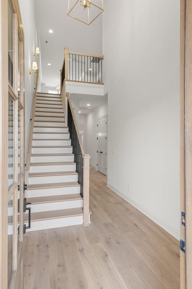 staircase featuring a notable chandelier and hardwood / wood-style flooring