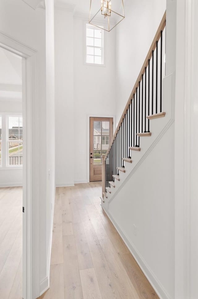 entryway with light wood-type flooring and a chandelier