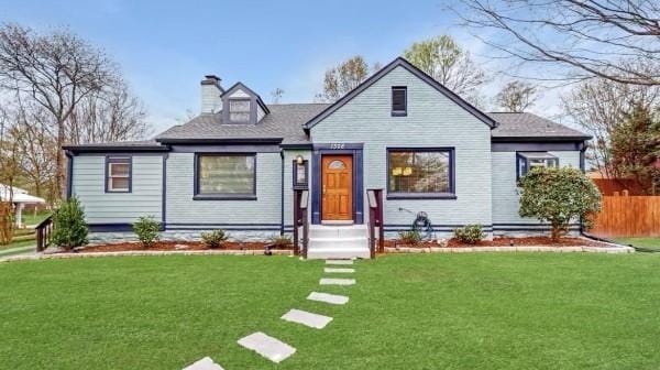 bungalow-style house featuring a front lawn, a chimney, and fence