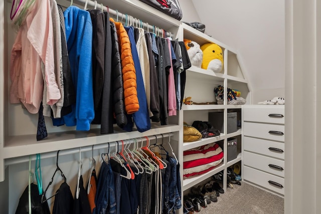 walk in closet with carpet floors and vaulted ceiling