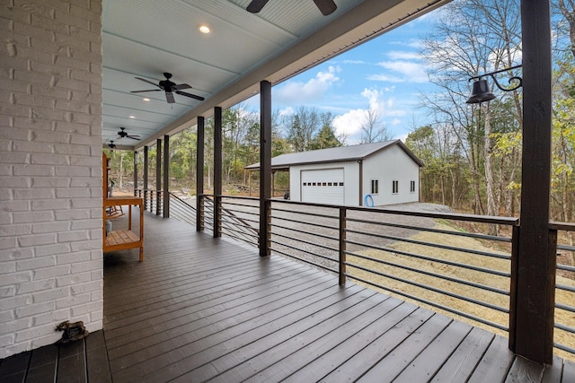 wooden terrace with an outbuilding, a garage, and ceiling fan