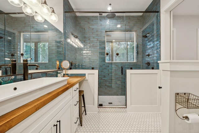 bathroom featuring tile patterned floors, vanity, a healthy amount of sunlight, and walk in shower