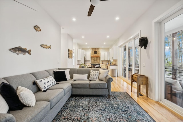 living room featuring ceiling fan and light wood-type flooring