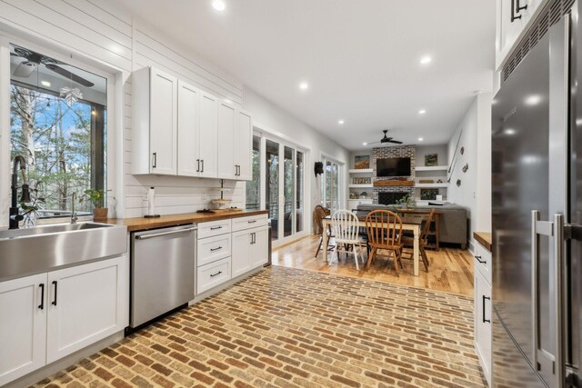 kitchen with white cabinetry, butcher block counters, sink, and appliances with stainless steel finishes