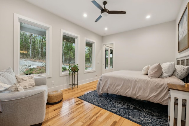 bedroom featuring multiple windows, light wood-type flooring, and ceiling fan