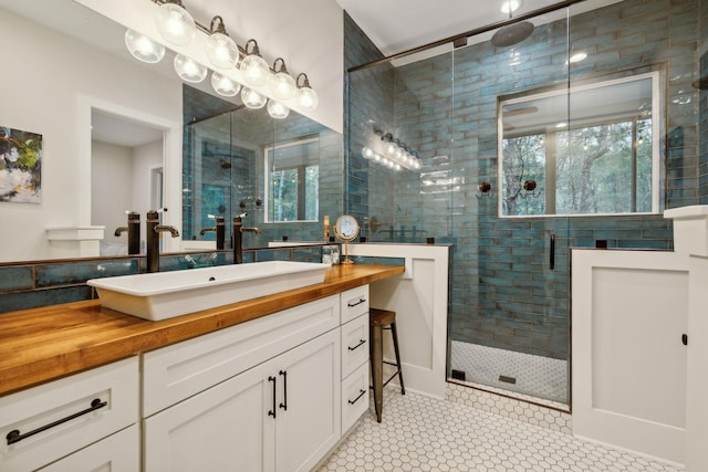 bathroom with tile patterned floors, vanity, and an enclosed shower