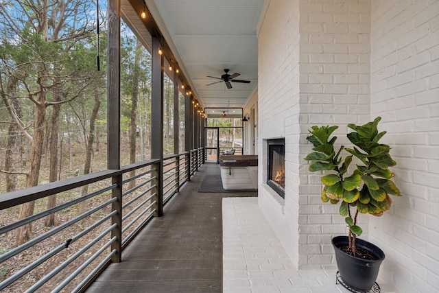 unfurnished sunroom featuring an outdoor brick fireplace